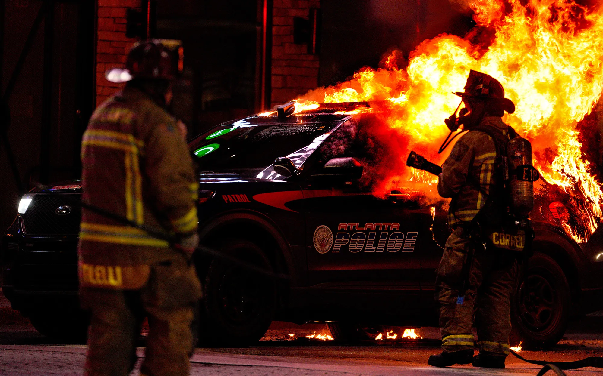 Firefighters work to extinguish a burning Atlanta police vehicle on Jan. 21.