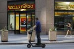 A person&nbsp;rides a scooter past a Wells Fargo & Co. bank branch in New York.