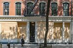A pedestrian wearing a protective mask walks past a boarded up store in New York.