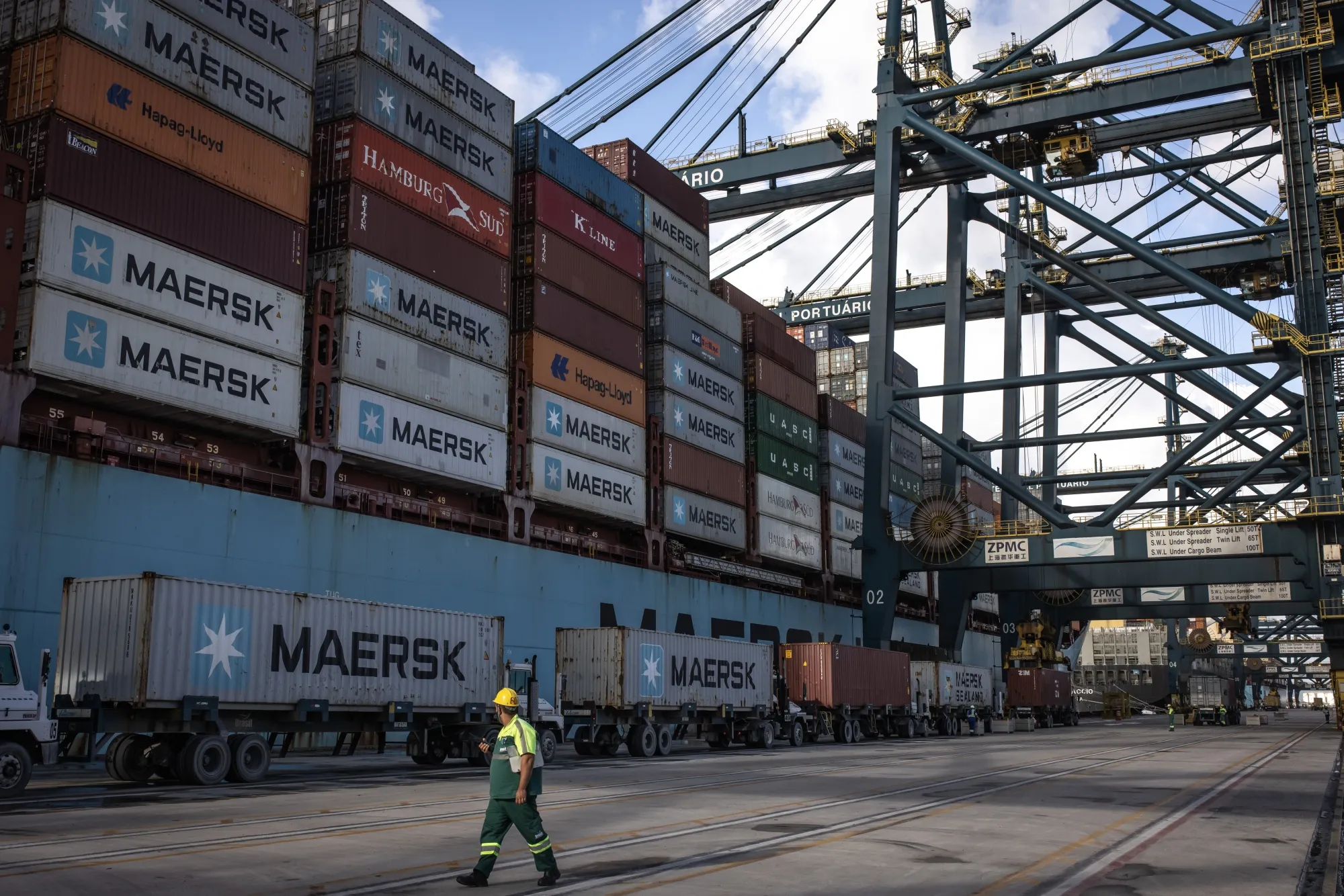 A worker walks past a docked vessel at an export terminal at the Port of Santos in Santos, Brazil.