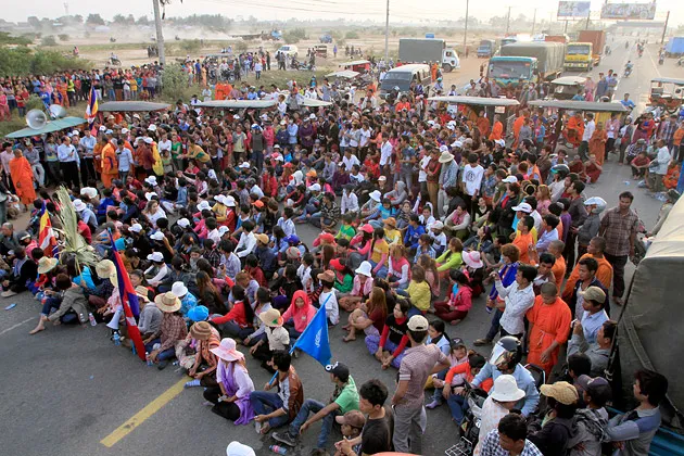 Cambodian garment workers and villagers block the main road demanding freedom for some worker activists who were arrested during a strike in Kambol village, on the outskirts of Phnom Penh, Cambodia on Jan. 2