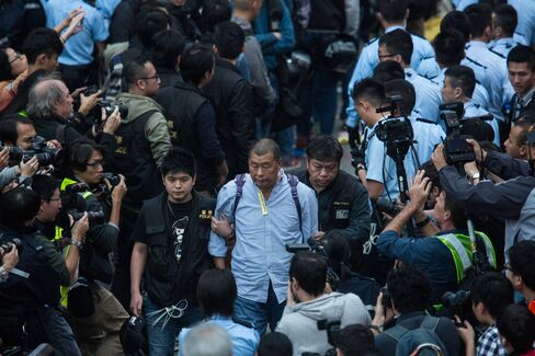 Hong Kong police officers detain Lai during raucous street protests in December.