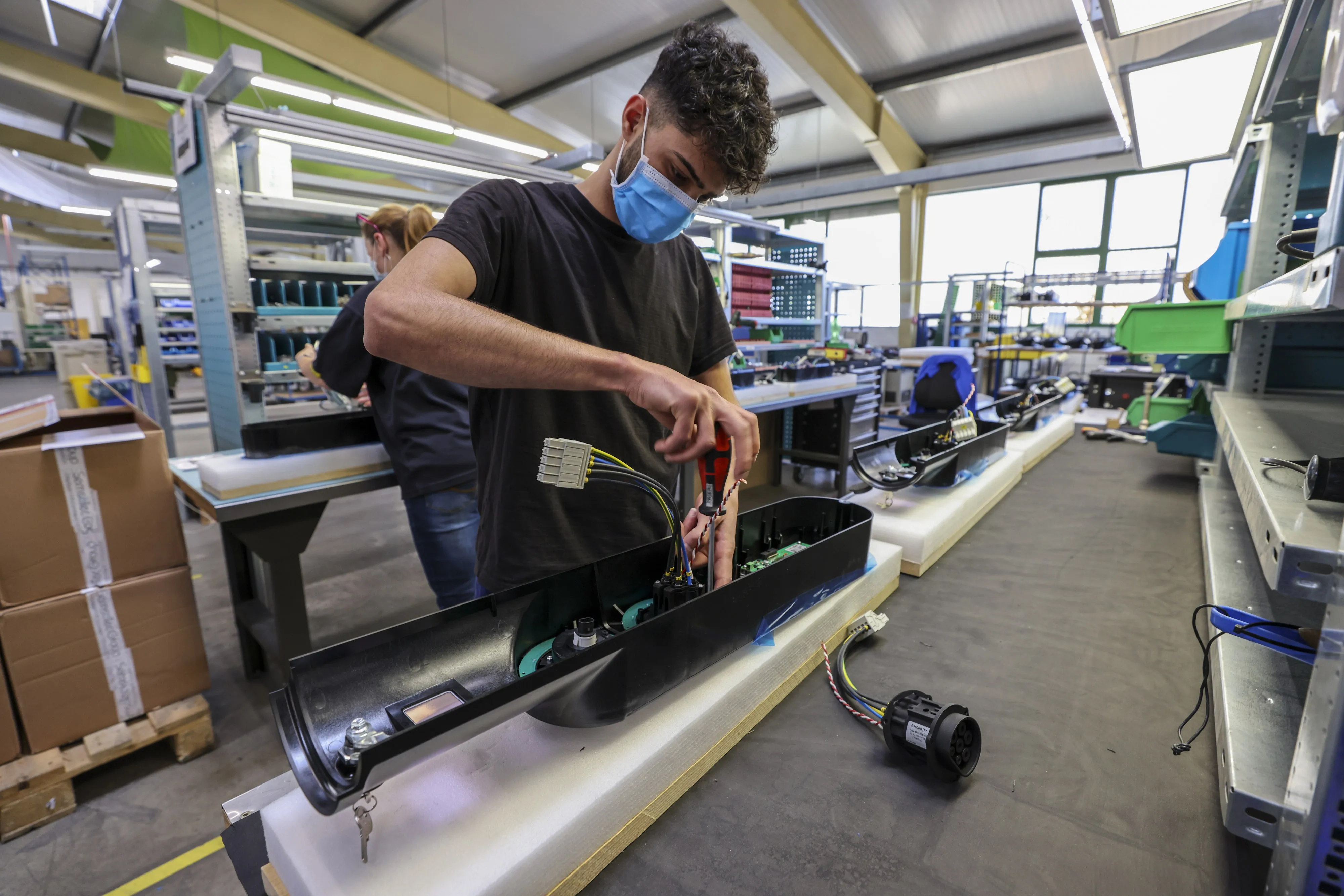 An employee assembles components inside an electric vehicle charging station near Treuchtlingen, Germany.