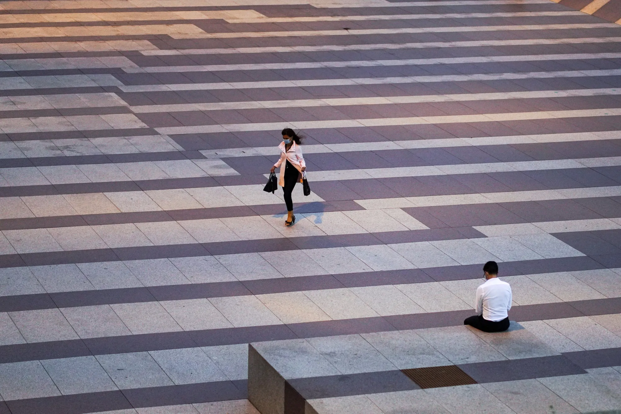 An office worker walks across a&nbsp;plaza&nbsp;in Madrid on Sept. 9.