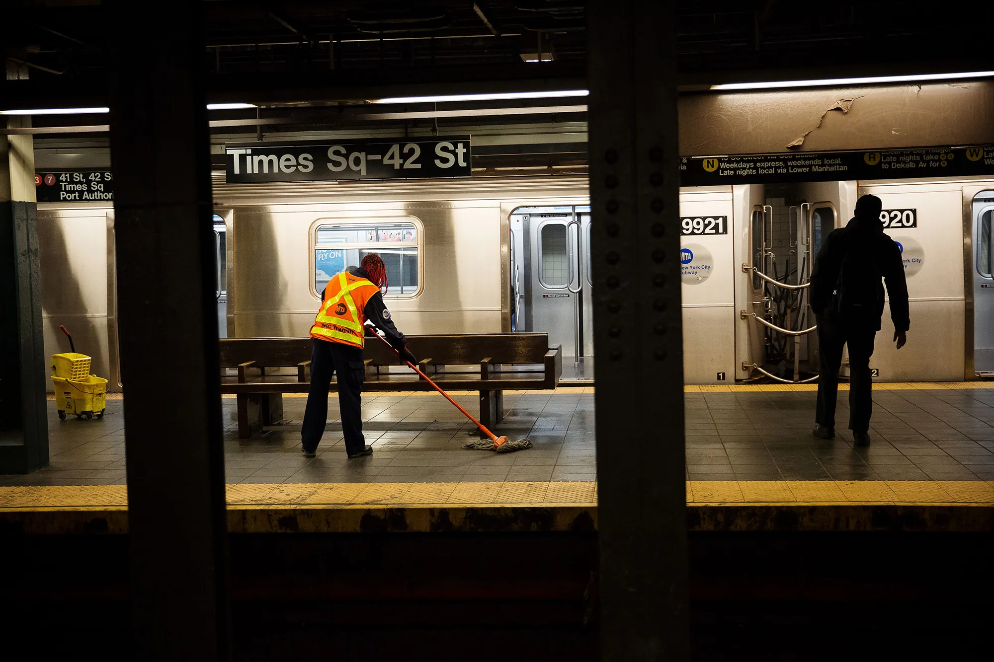 A Metropolitan Transit Authority (MTA) worker mops around a bench at a Times Square subway station in New York on April 21.