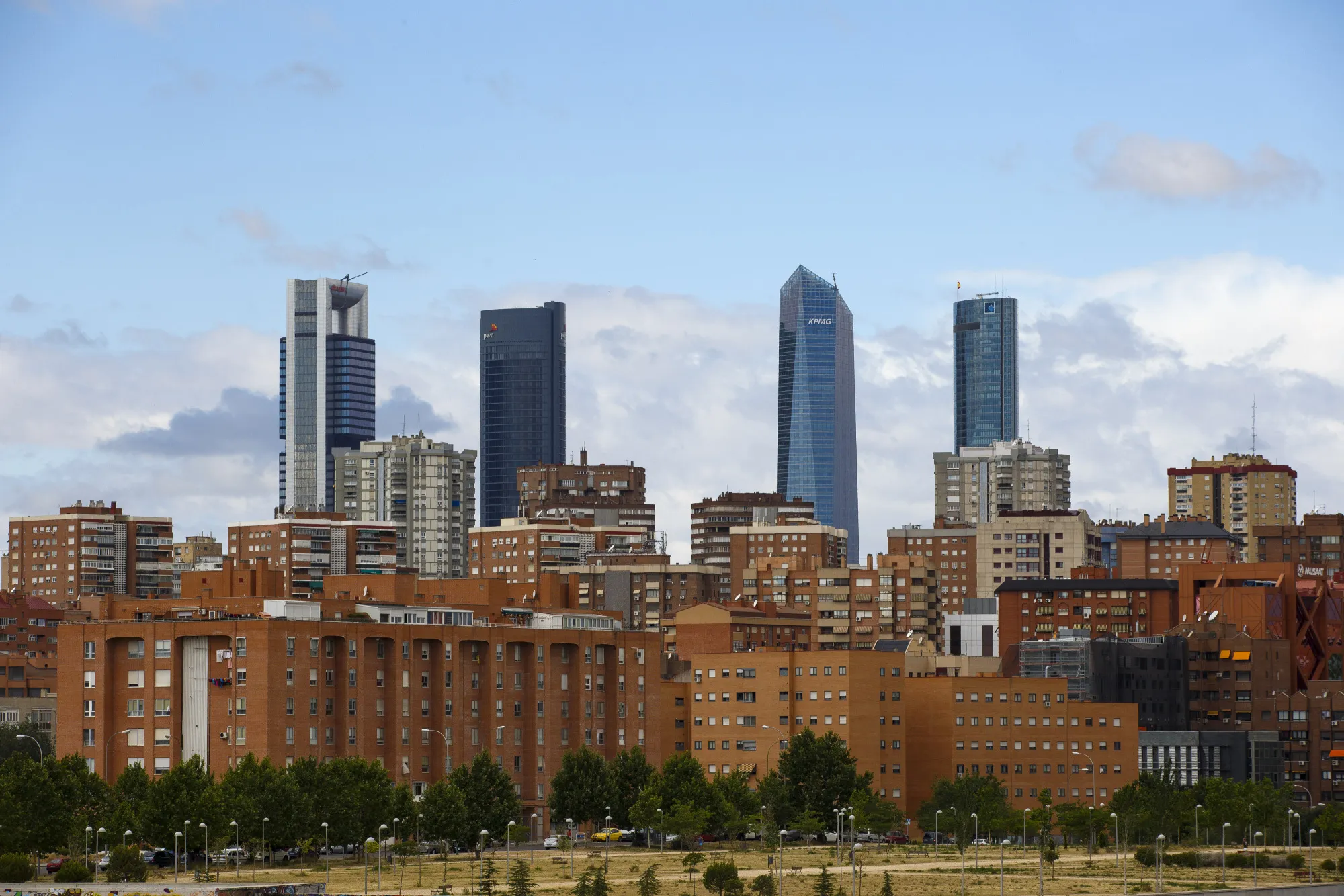 The four towers of the Cuatro Torres Business Area (CTBA) stand beyond residential housing blocks in Madrid, on Wednesday, June 28, 2017.