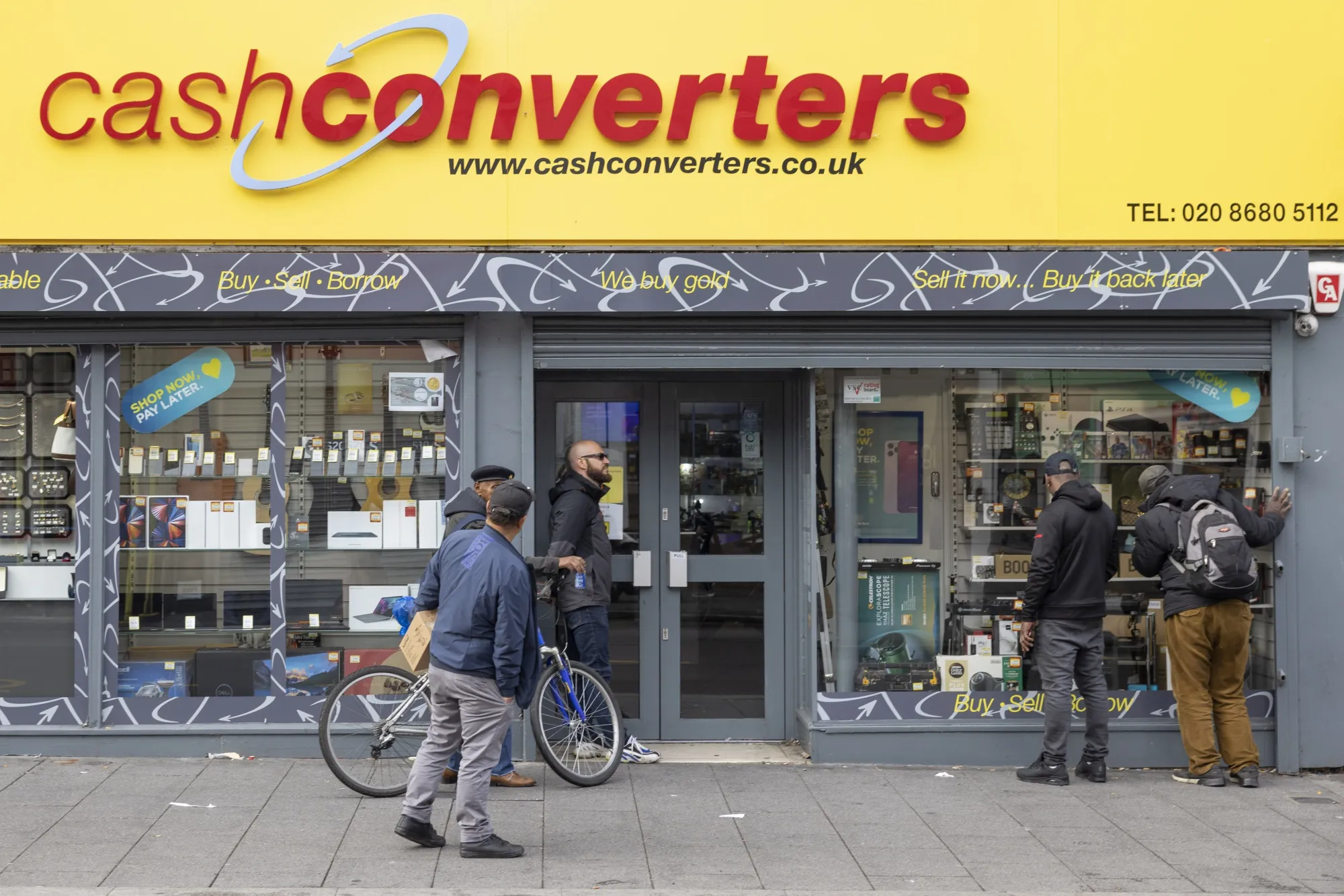 Customers wait outside a pawnbrokers shop before it opens in Croydon on Monday.