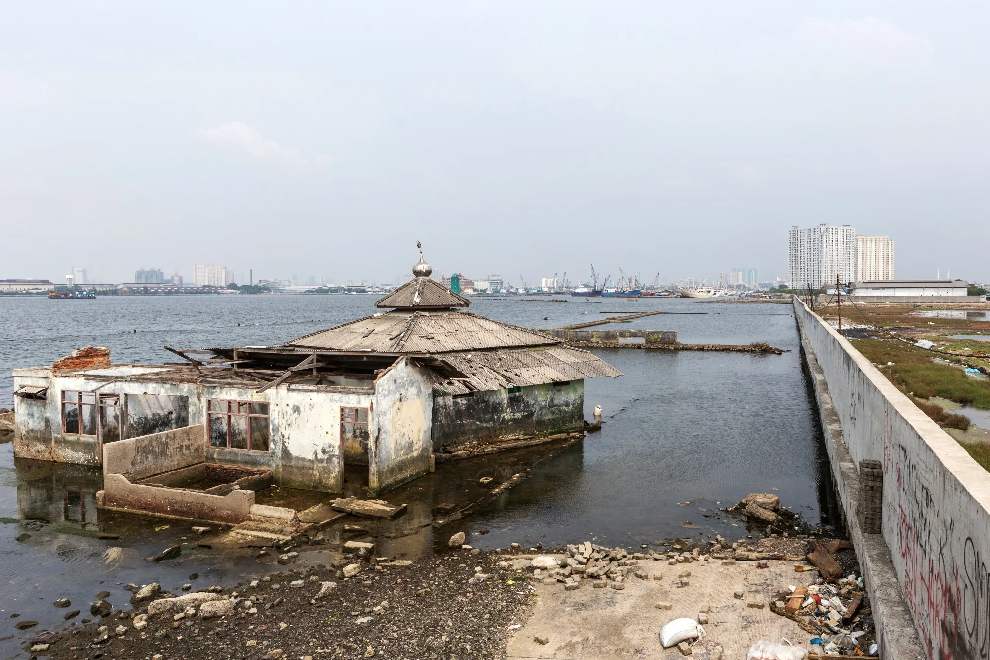 An abandoned mosque stands beyond a sea wall in the Muara Baru area of Jakarta, Indonesia, May 10, 2019.