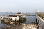 An abandoned mosque stands beyond a sea wall in the Muara Baru area of Jakarta, Indonesia, May 10, 2019.