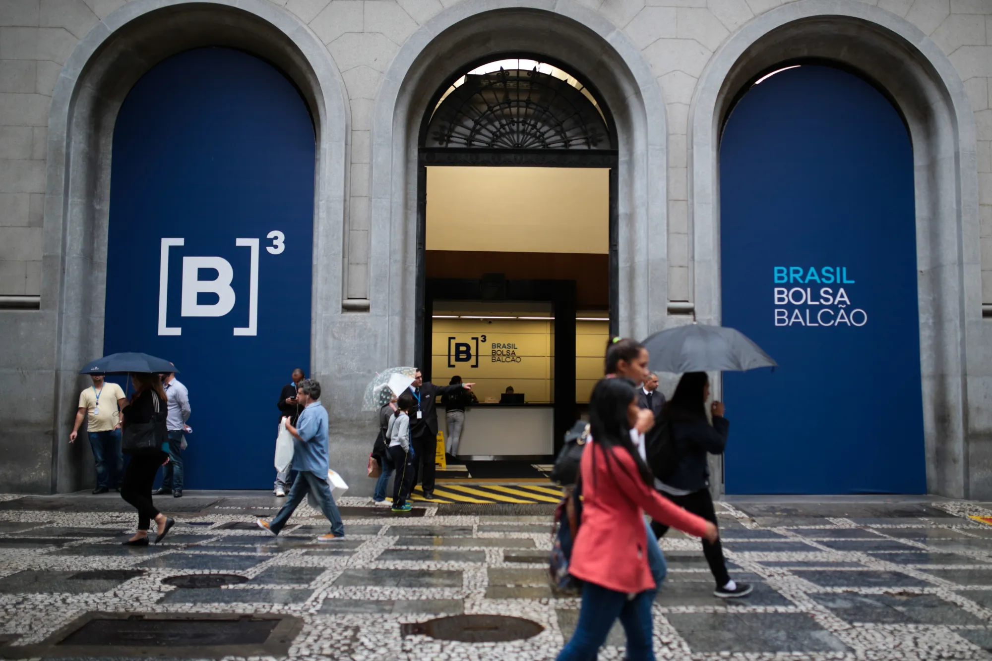 Pedestrians walk by the Brasil Bolsa Bacao stock exchange in Sao Paulo.
