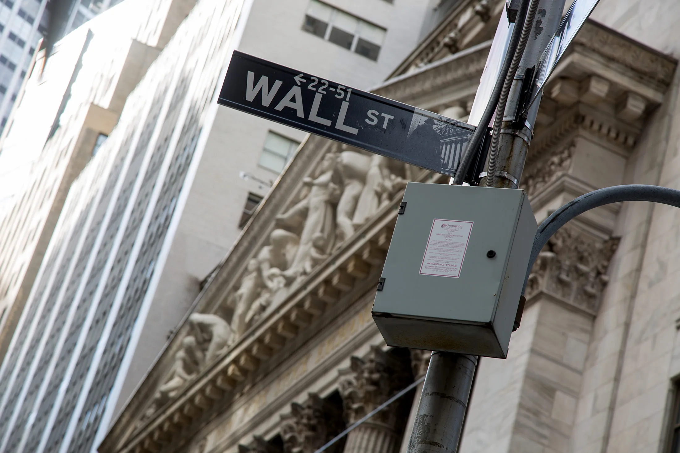 A Wall Street sign is displayed outside the New York Stock Exchange (NYSE) in New York.
