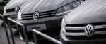 A Volkswagen badge sits on a Volkswagen Sharan automobile displayed on the forecourt of a dealership in Vienna.