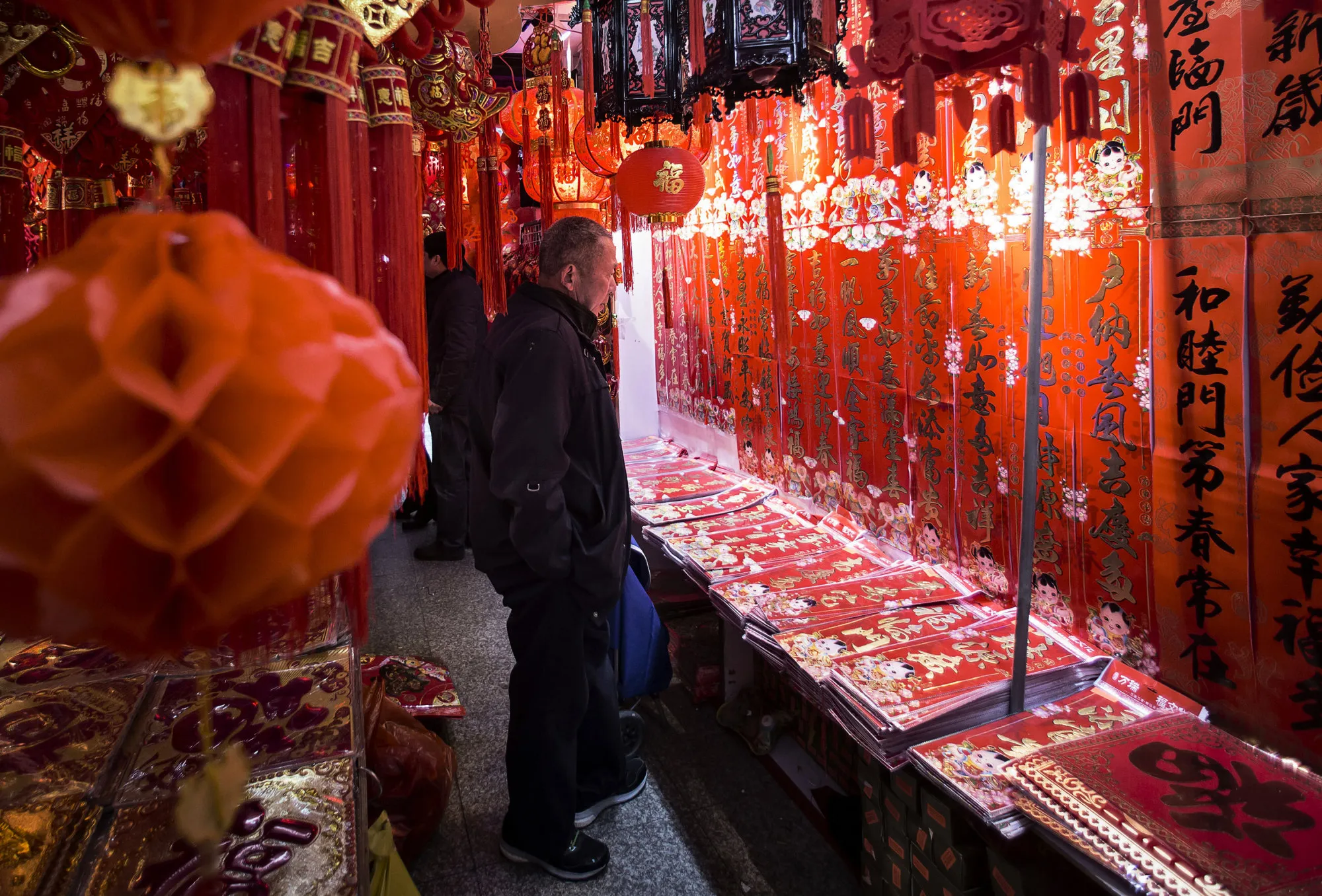 A customer looks at Chinese calligraphy decorations for Lunar New Year at a market stall in Shanghai, China, on Thursday, Feb. 4.
