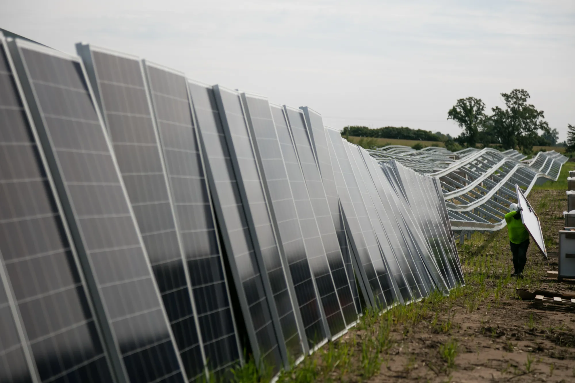 A worker unpacks solar panels at the Connexus Energy Athens Township solar-plus-storage project site in Athens Township, Minnesota, U.S., on Wednesday, Sept. 5, 2018. Connexus Energy Athens Township project integrates large scale battery storage with a solar array to manage peak demand and is the first commercial-battery deployment in Minnesota.
