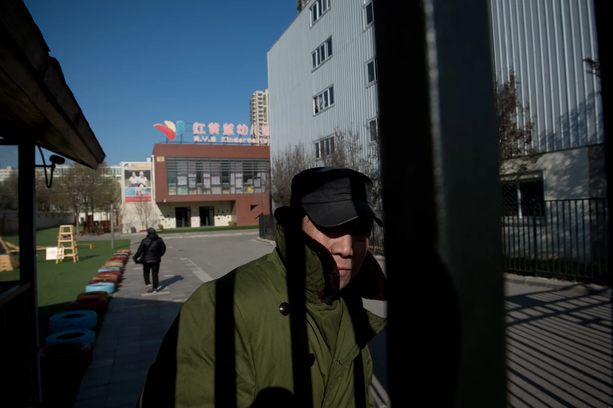A security guard stands behind the gate of the RYB Education New World kindergarten in Beijing on Nov. 24.