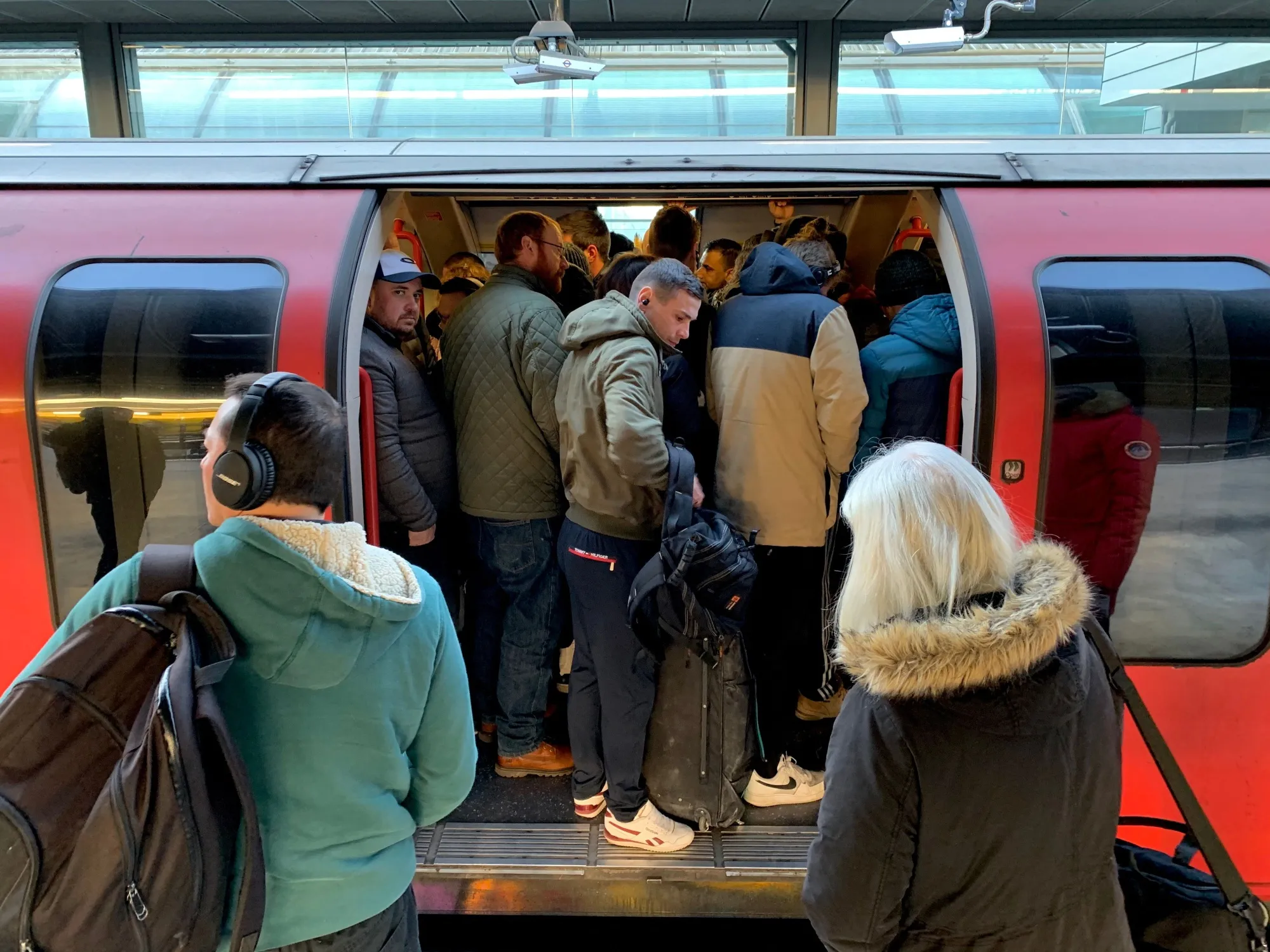 Passengers squeeze on to a busy Central Line underground train at Stratford station.