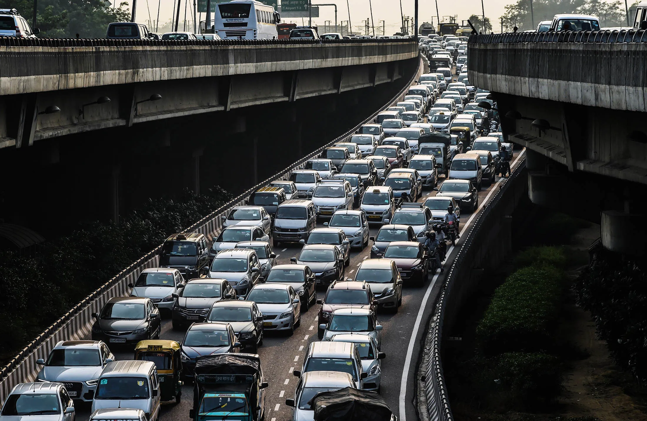 To go with Climate-warming-UN-COP21-India,FOCUS by Trudy Harris In this photo taken on October 15, 2015, a stream of cars backs up on an exit to a highway in New Delhi. India's capital, with 18 million residents, has the world's most polluted air with six times the amount of small particulate matter (pm2.5) than what is considered safe, according to the World Health Organization (WHO). The air's hazardous amount of pm2.5 can reach deep into the lungs and enter the blood, causing serious long term health effect, with the WHO warning India has the world's highest death rate from chronic respiratory diseases. India, home to 13 of the world's top 20 polluted cities, is also the third largest emitter of greenhouse gases behind the United States and China. In Delhi, the air pollution is due to vehicle traffic including cargo trucks running on low-grade diesel, individual fires that residents burn in winter, crop being burnt by farmers in neighboring states, and construction site dust. Burning coal in power plants is also major contributor that is expected to increase hugely in the coming decades to match electricity needs of the ever-growing city and its booming satellite towns. AFP PHOTO / ROBERTO SCHMIDT (Photo credit should read ROBERTO SCHMIDT/AFP/Getty Images)
