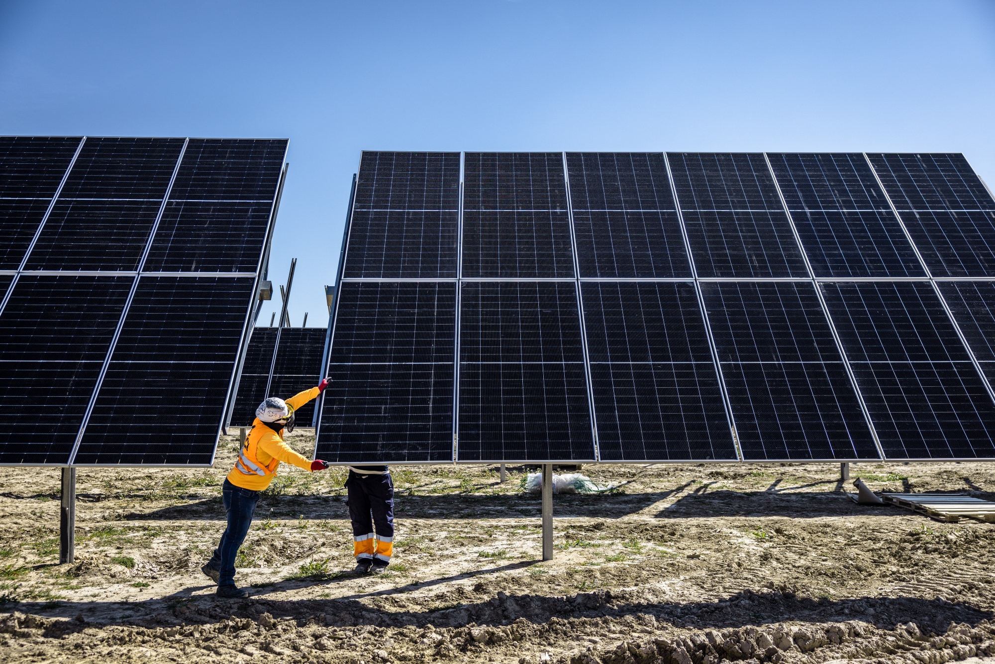 Workers install solar panels