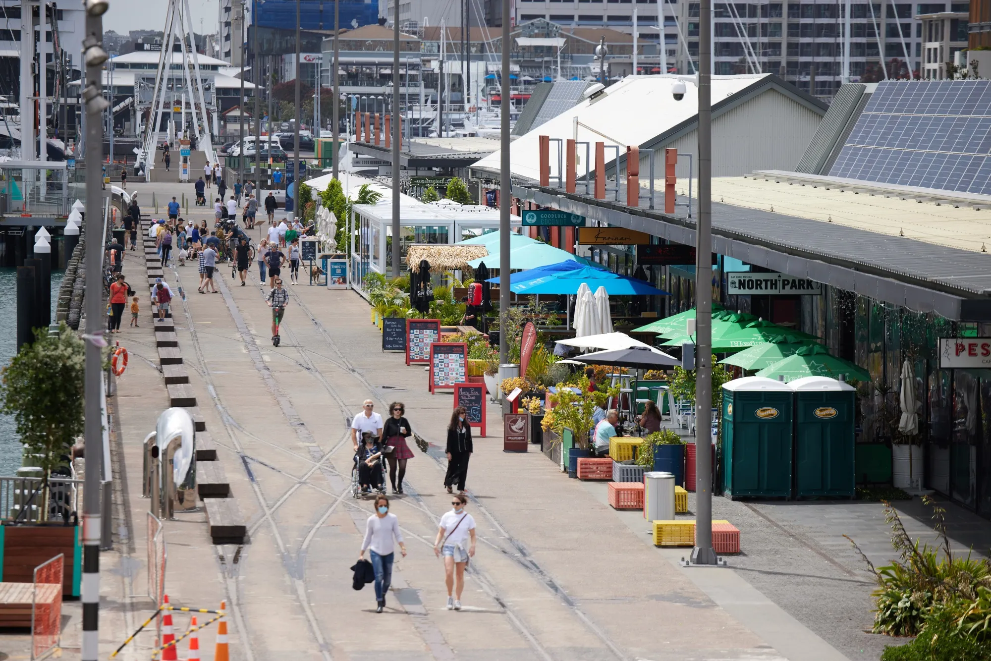 Pedestrians walk past cafes and restaurants in Auckland, New Zealand.