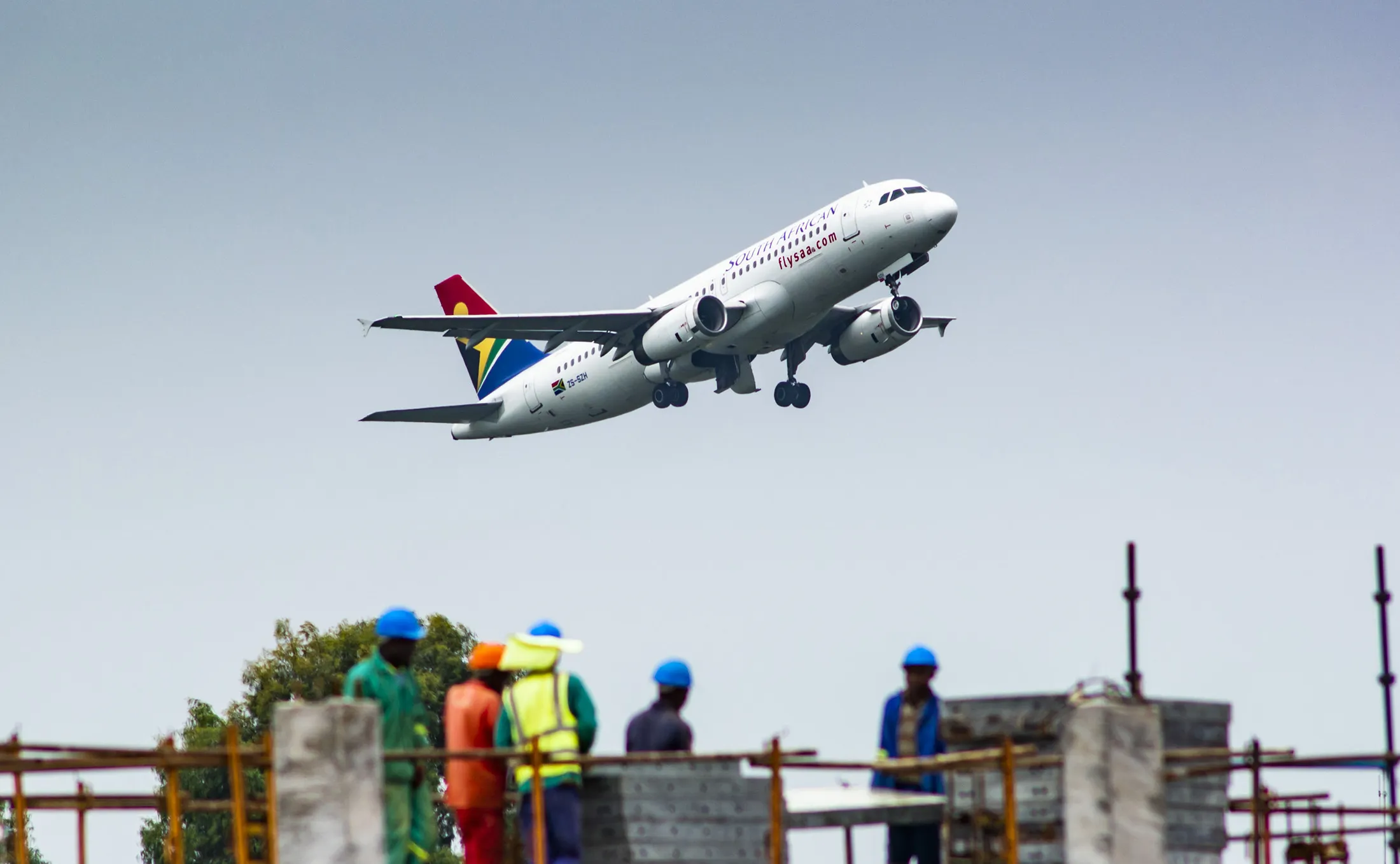 A passenger jet, operated by South African Airlines, flies above a construction site during take-off from O.R. Tambo International Airport in Johannesburg.