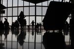 The silhouettes of travelers are seen walking at Phoenix Sky Harbor International Airport (PHX) in Phoenix, Arizona, U.S., on Sept. 6, 2013.
