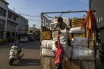 Workers unload goods from a truck in the main market area in Gandhidham, India.