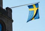 A national flag of Sweden hangs from a commercial building in Stockholm, Sweden.