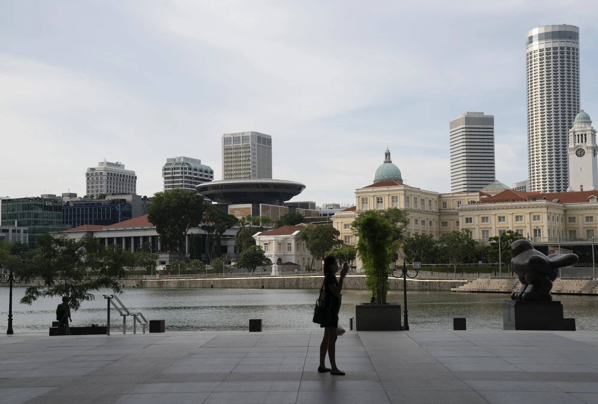 A solo pedestrian uses a smartphone by the Singapore River in the business district during a partial lockdown in Singapore on April 9.
