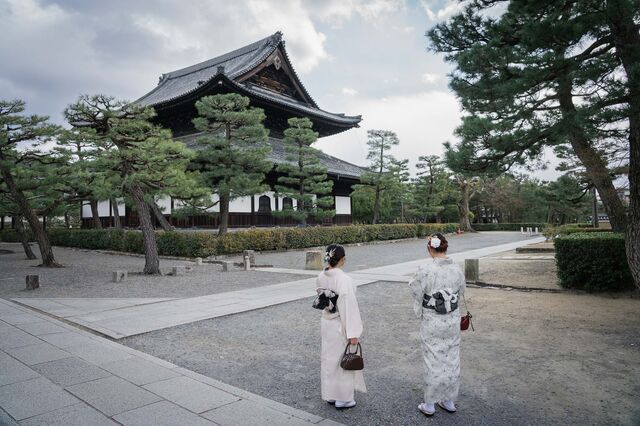 Two women in kimonos stand in the Gion district, where visitors go to see geisha.