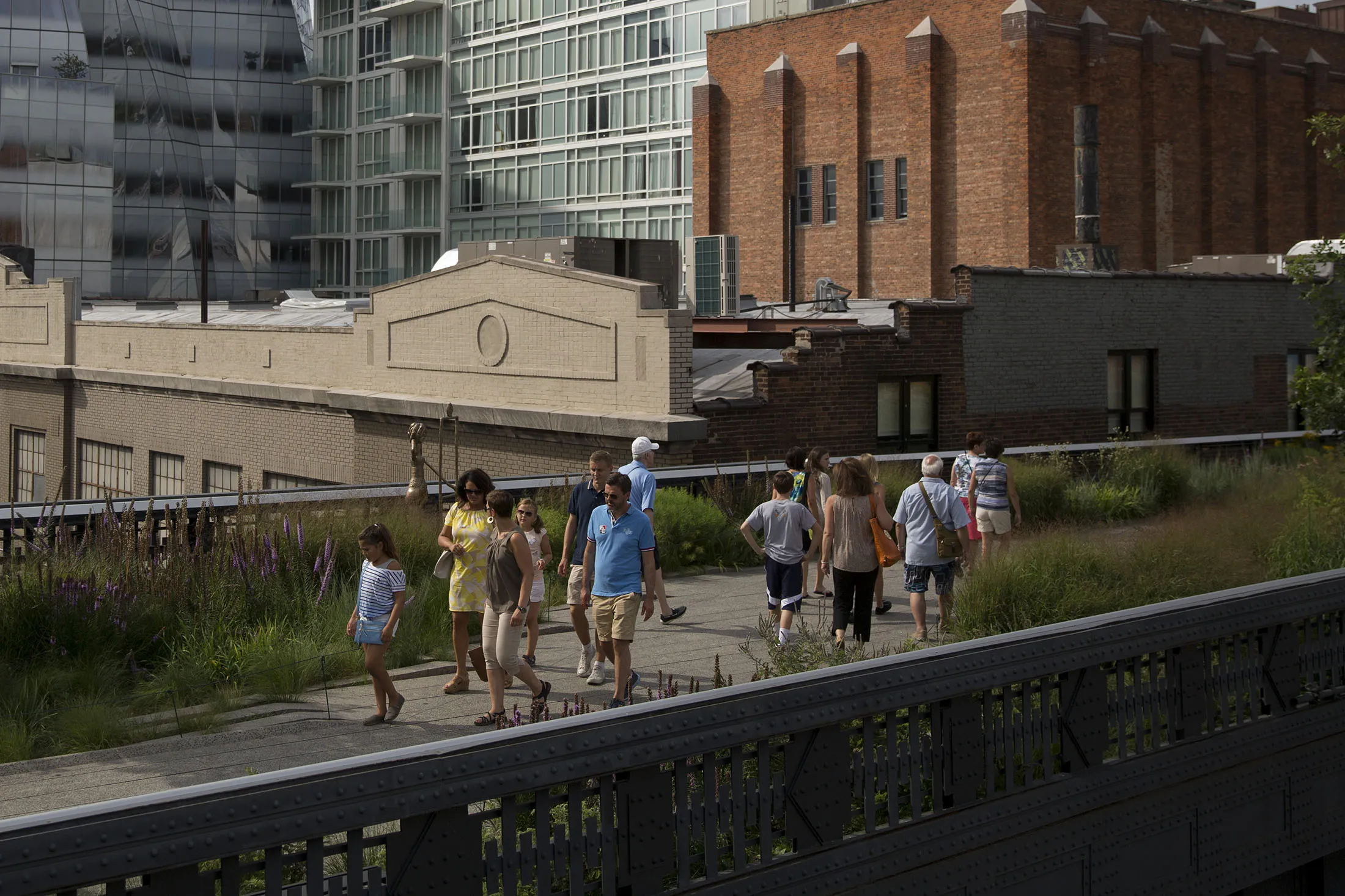 Pedestrians walk along the High Line park in New York, U.S., on Wednesday, July 24, 2013. The U.S. Conference Board is scheduled to release consumer confidence figures on July 30.
