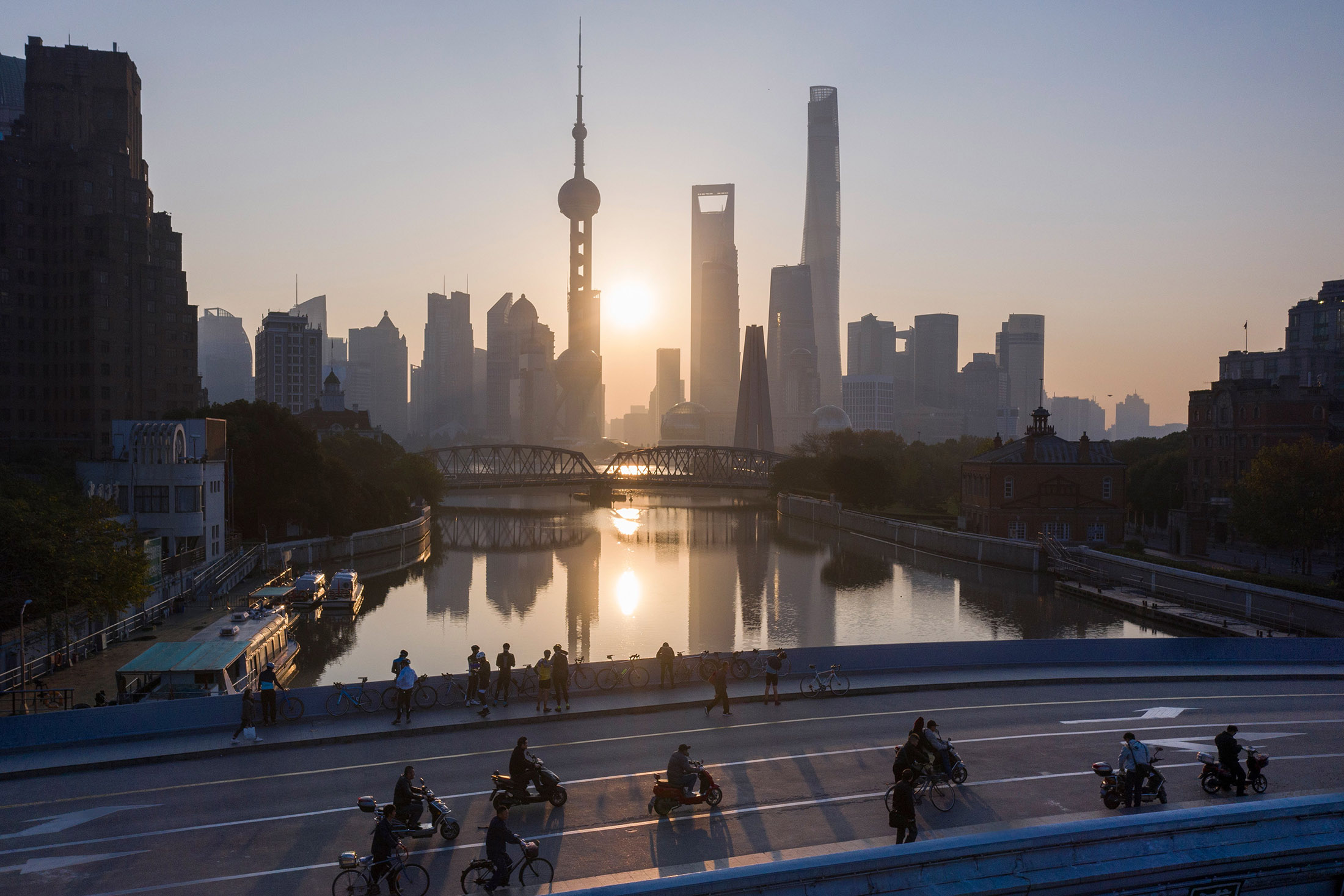 This aerial picture shows the sun rising behind the skyline of Shanghai.