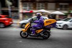 A courier for the food delivery service Getir rides along a street in Barcelona, Spain.