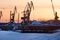 Shipping cranes stand on the harbor at the port beside the frozen River Ob in Nizhnevartovsk, Russia, on Sunday, March 19, 2017. Russia's largest oil field, Samotlor, so far past its prime that it now pumps almost 20 times more water than crude, could be on the verge of gushing profits again for Rosneft PJSC. Photographer: Andrey Rudakov/Bloomberg
