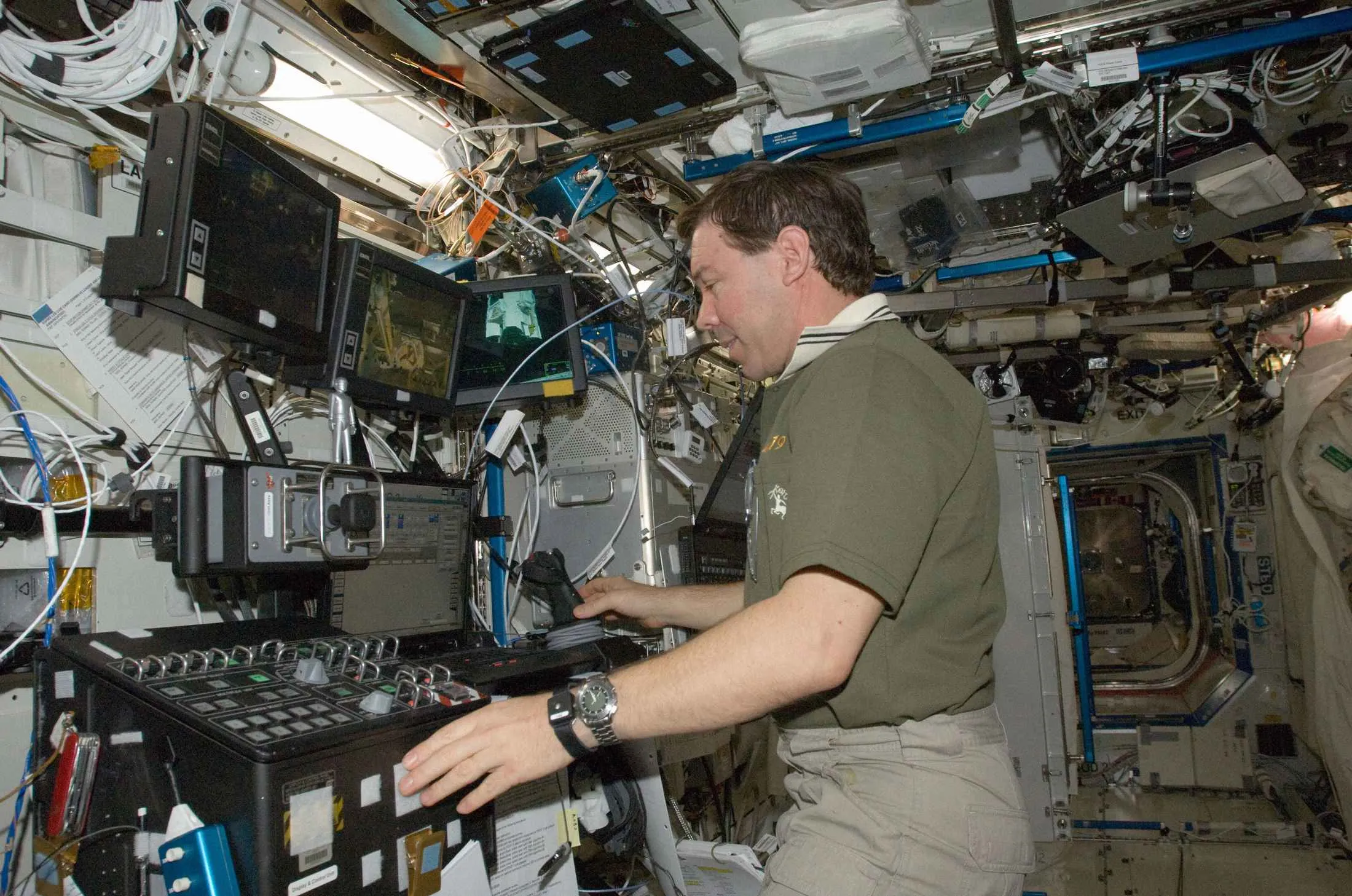 Astronaut Michael Barratt&nbsp;works the controls at the Canadarm2 robotic workstation in the Destiny laboratory of the International Space Station.