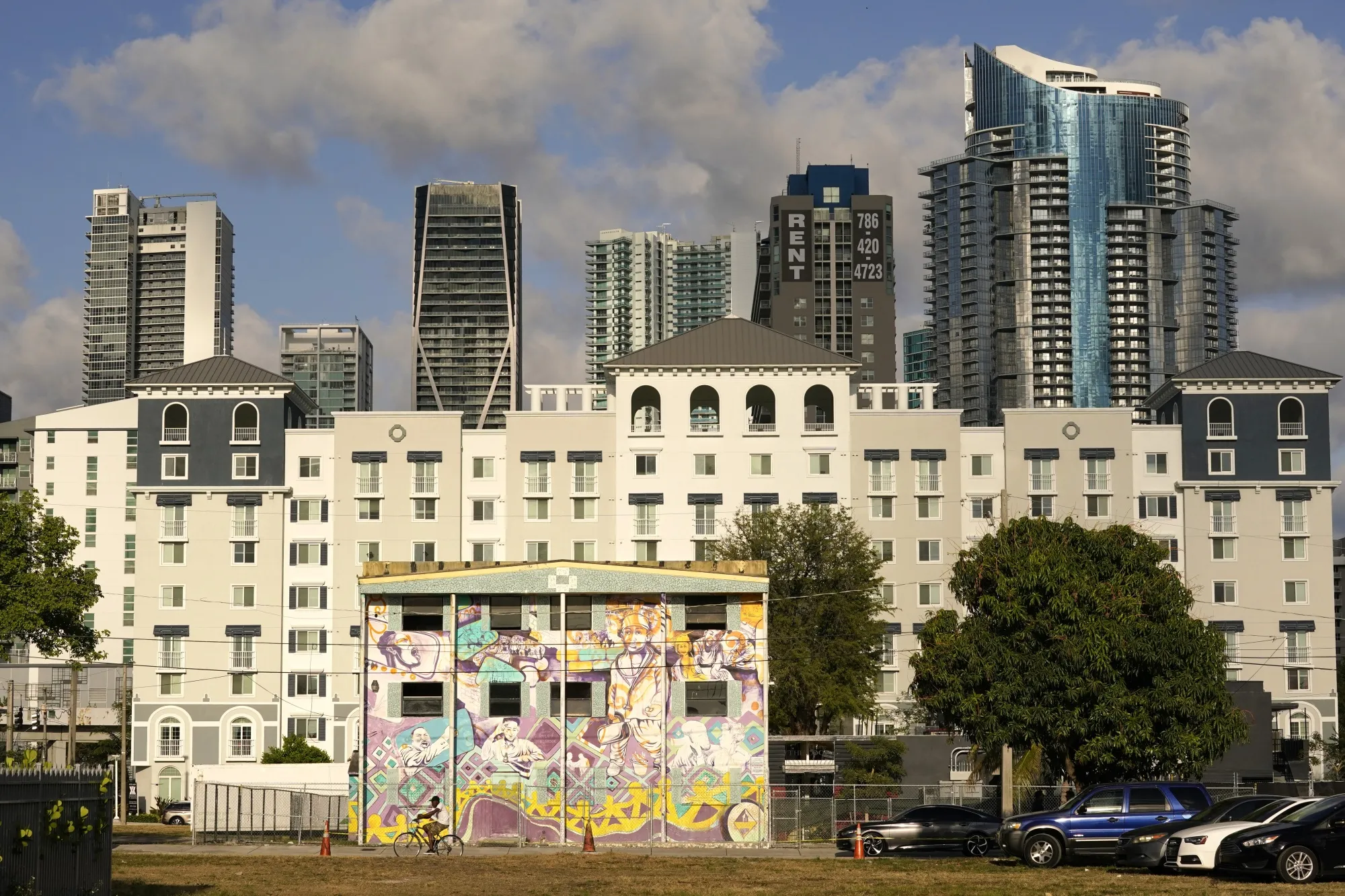 The skyline of downtown Miami is the backdrop for the the Plaza at the Lyric apartment building and a vacant building painted over with murals in the Overtown neighborhood of Miami.
