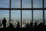 Visitors look out from the observation deck of the Roppongi Hills Mori Tower, operated by Mori Building Co., in Tokyo, Japan, on Monday, March 18, 2019.