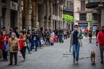 People queue along the street to collect food aid from a distribution point at the Santa Anna church in Barcelona, on May 17.