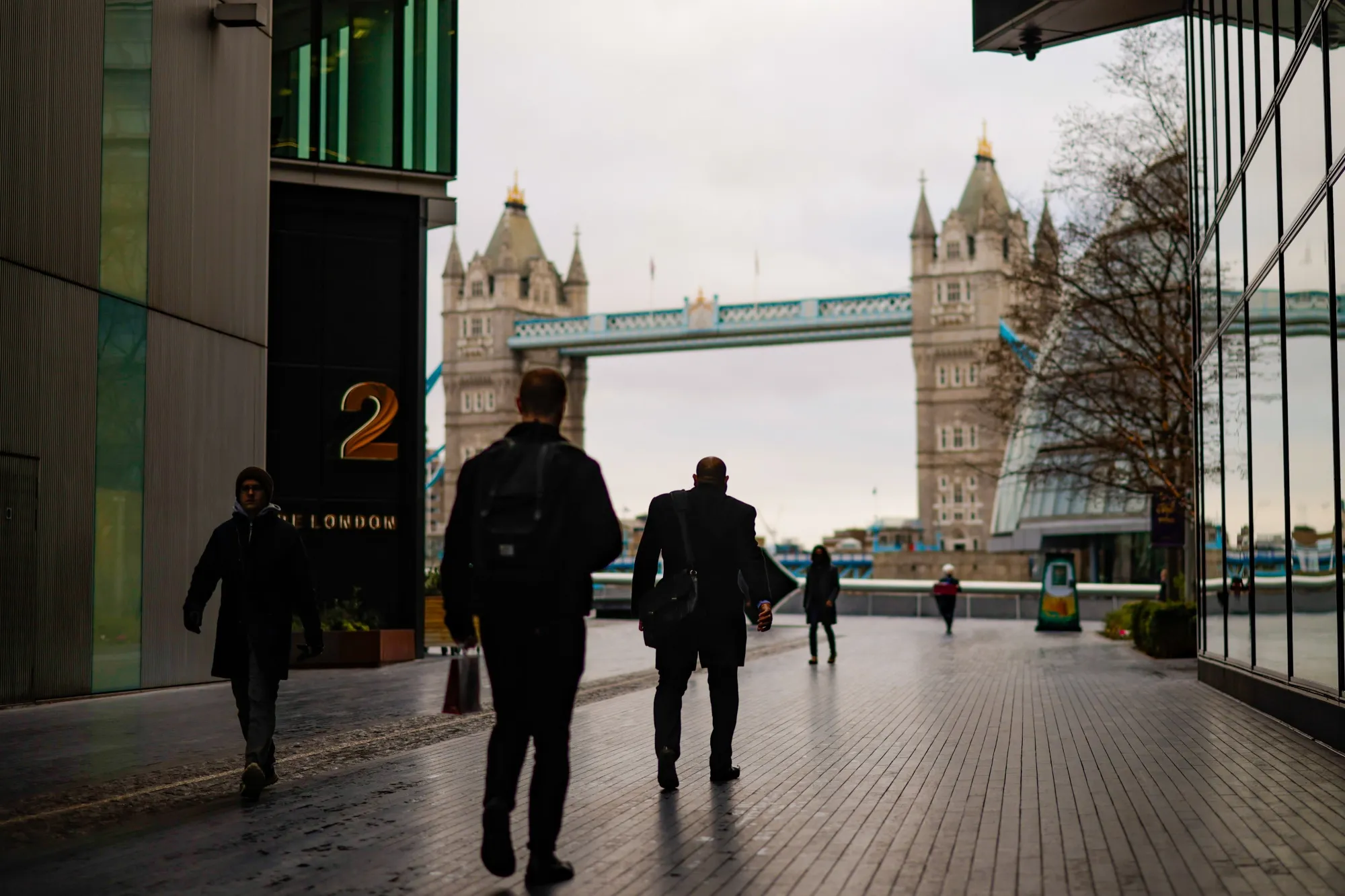 Pedestrians walk towards Tower Bridge in London.