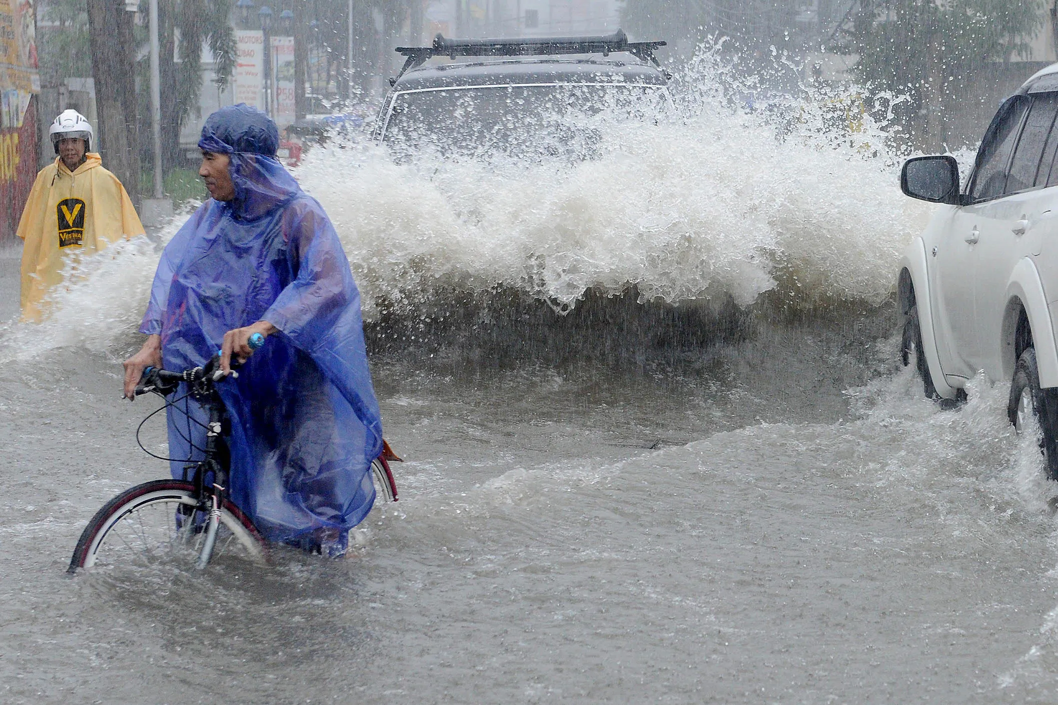 Commuters make their way through a flooded street in the suburbs of Manila.
