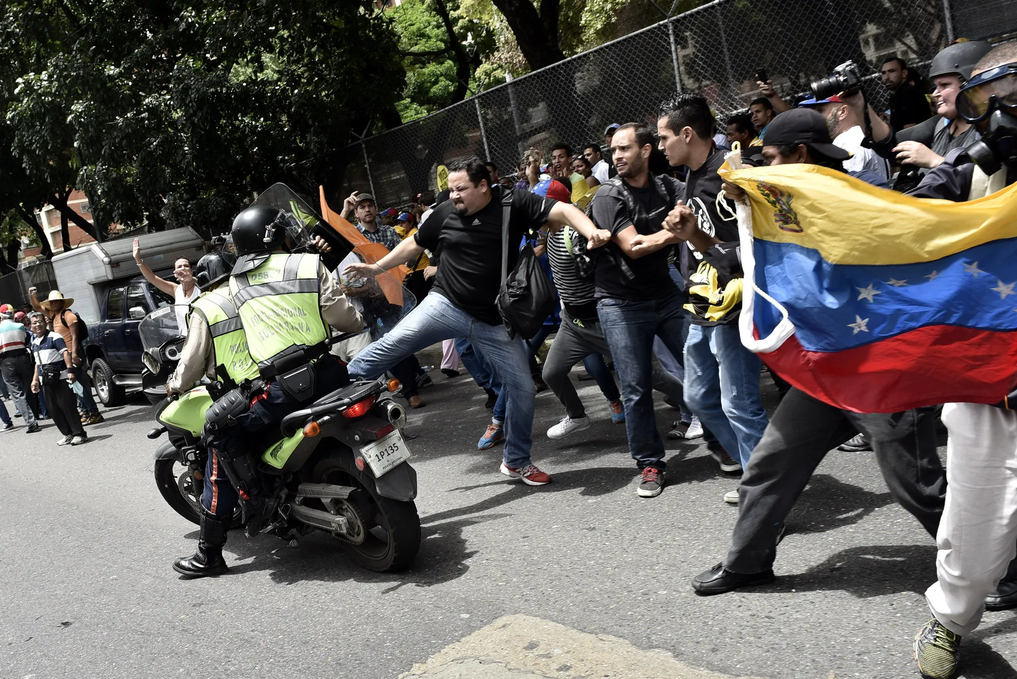 A protester kicks a Bolivarian National Police vehicle during pro-opposition demonstrations in Caracas on June 7.
