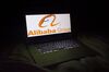 The Alibaba Group Holding Ltd. logo is seen on a laptop screen in an arranged photograph.