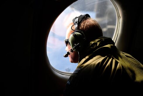 A crew member looks out an observation window aboard a Royal New Zealand Air Force (RNZAF) P3 Orion maratime search aircraft as it flies over the southern Indian Ocean looking for debris from missing Malaysia Airlines flight MH370 on April 11, 2014.