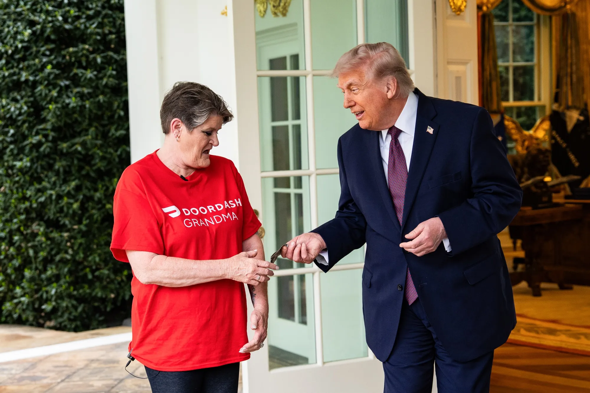 Donald Trump tips Sharon Simmons, a DoorDash worker, outside the Oval Office.
