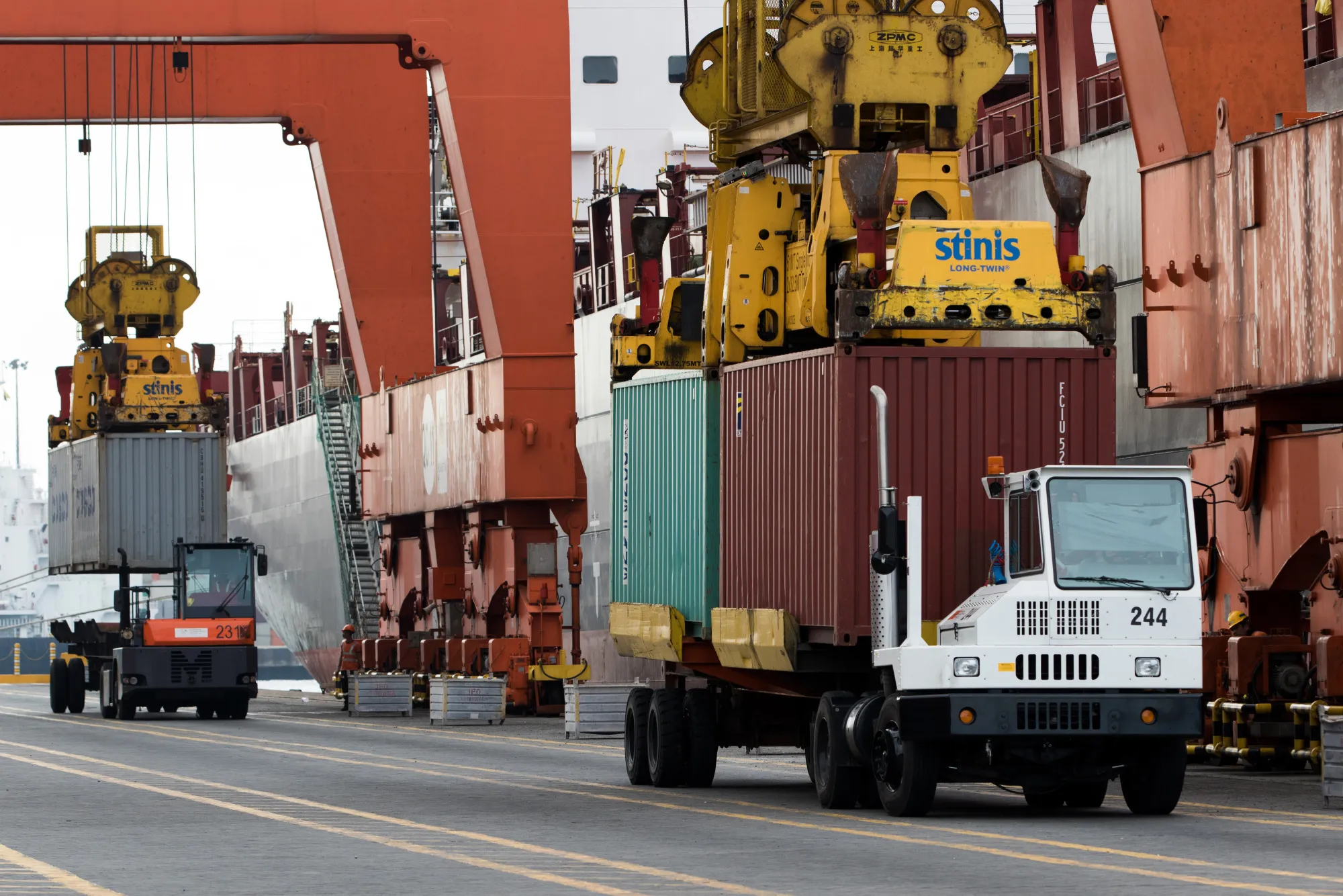 Gantry cranes load containers onto trucks at Manila International Container Terminal (MICT) at the Port of Manila in Manila, the Philippines, on Friday, Nov. 20, 2015. The Philippines is scheduled to release third quarter gross domestic product (GDP) figures on Nov. 26.