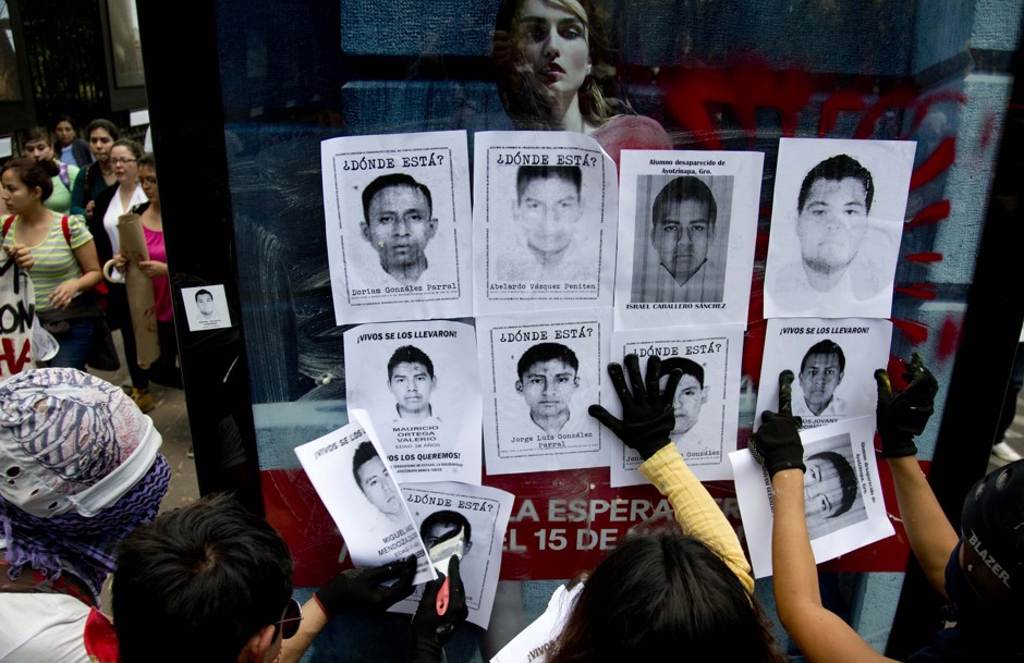 Demonstrators place missing persons posters for 43 students whose disappearance was later linked to José Luis de Abarca, mayor of the Mexican city of Iguala.