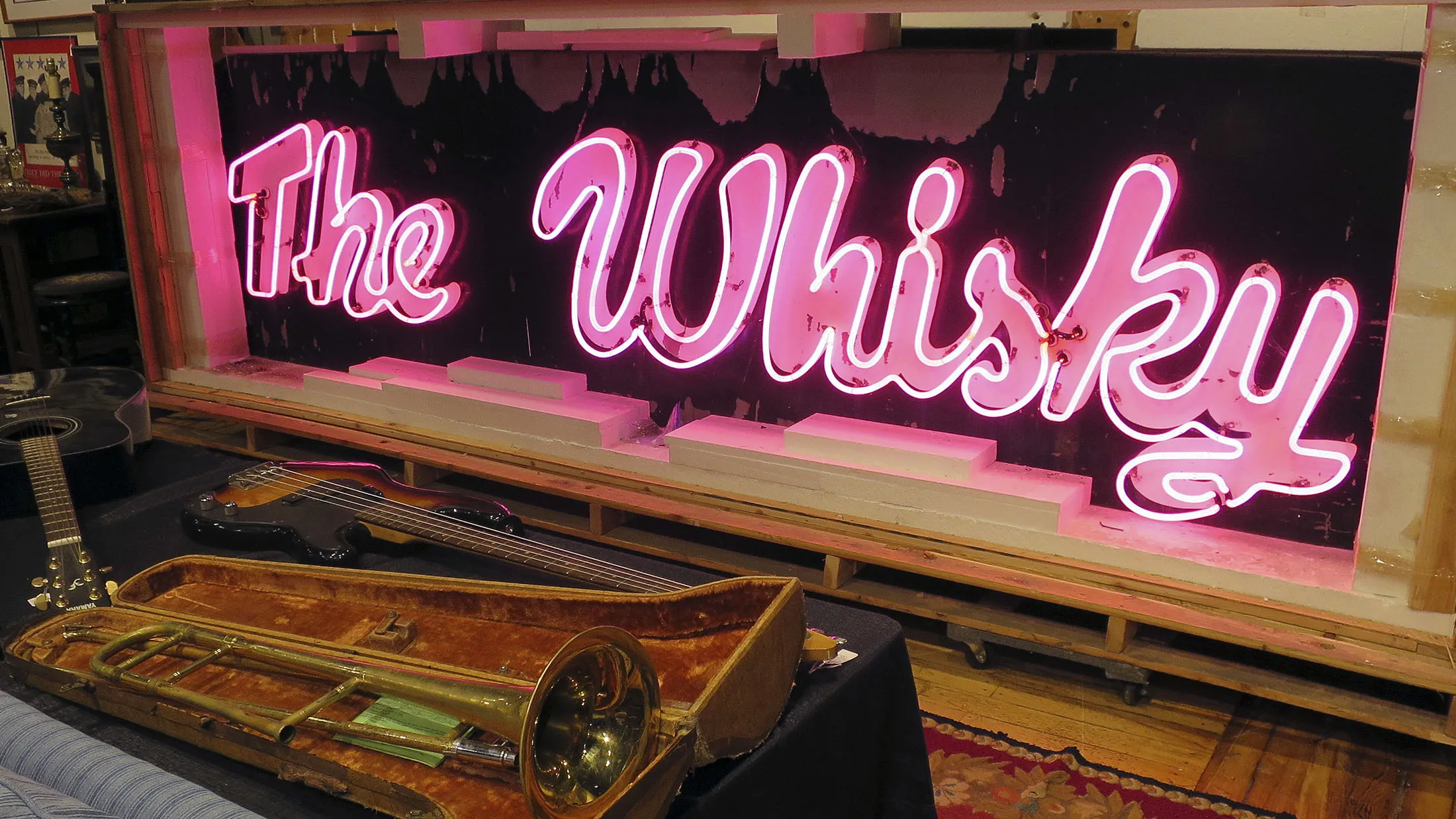 In this Friday, Jan. 20, 2017 photo, a marquee from the legendary Los Angeles rock 'n' roll club, Whisky a Go Go, glows at the Saco River Auction Co., in Biddeford, Maine. The sign that adorned the West Hollywood club during the heyday of punk, new wave and grunge in the 1980s and '90s, will go up for auction on Wednesday, Jan. 25.
