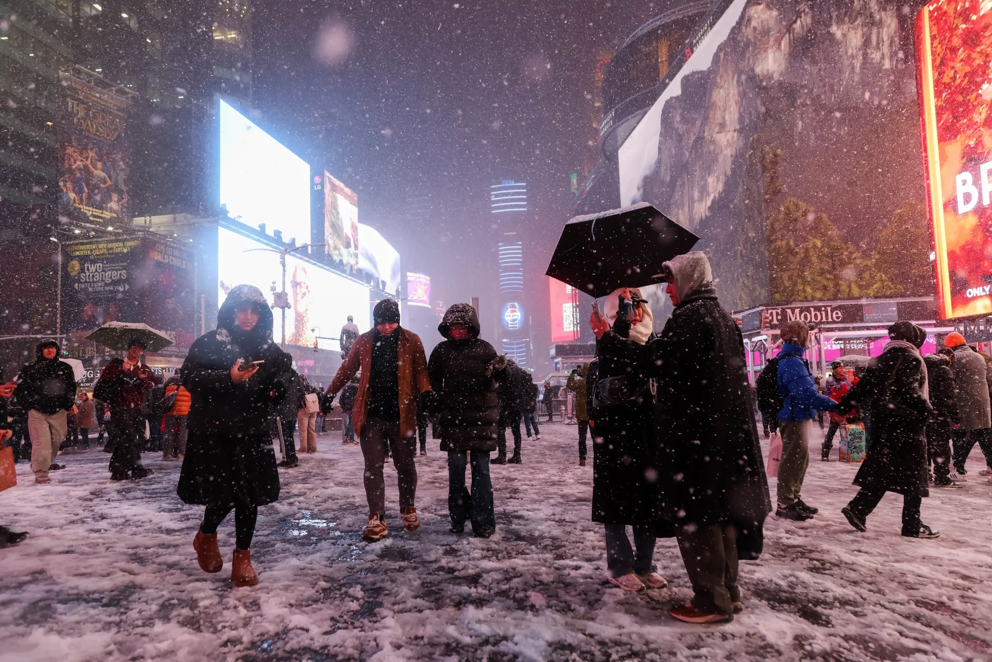 Pedestrians in the snow at Times Square during a winter storm in New York.