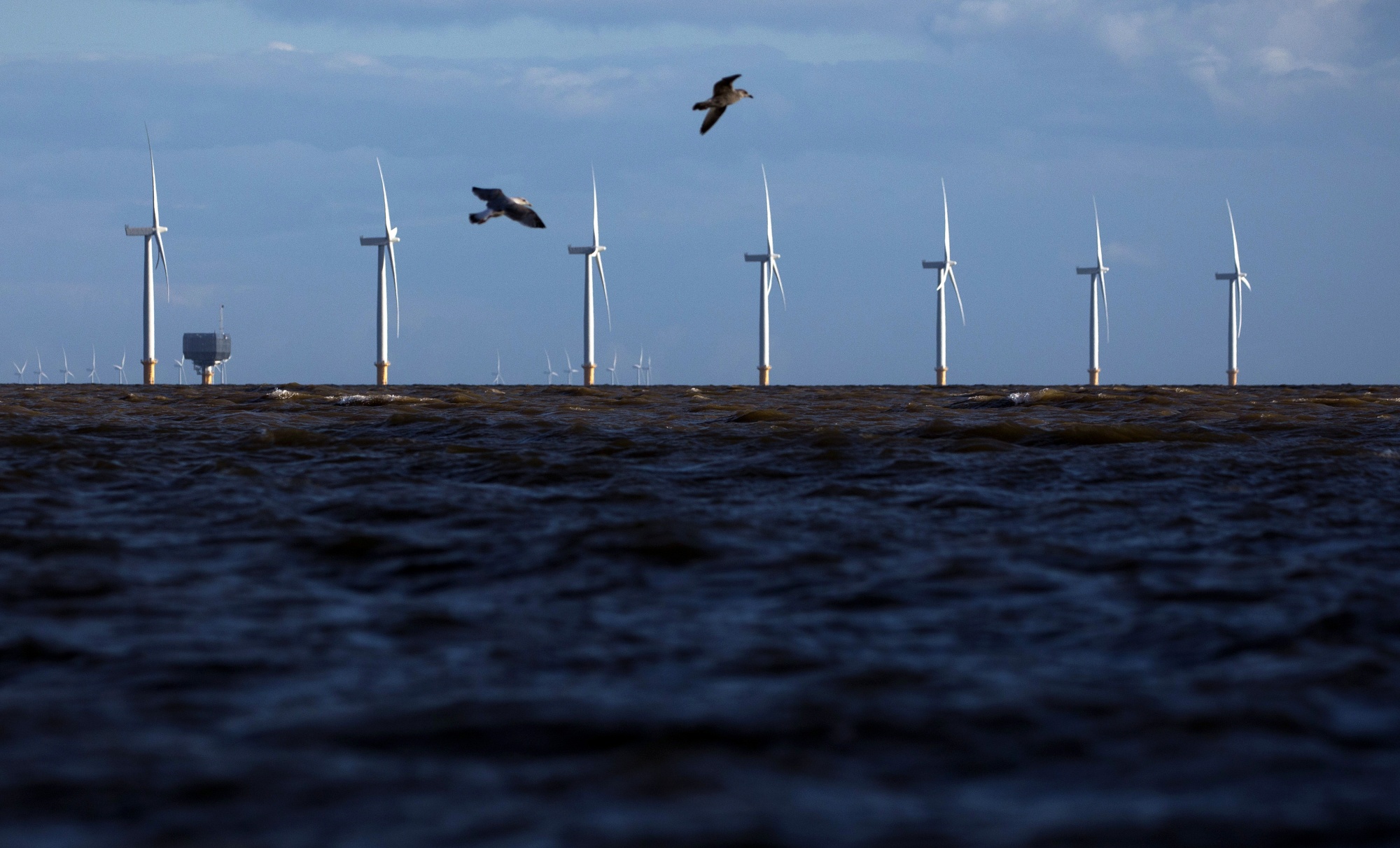 Offshore wind turbines off the coast in Clacton On Sea, UK.