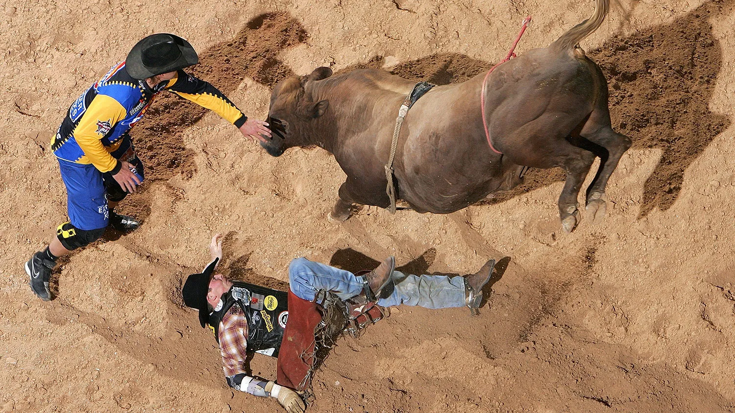 Scott Schiffner of the U.S. tries to get away from “Too Sharp” as a bullfighter comes in to help during the Professional Bull Riders World Finals on Oct. 27, 2006, in Las Vegas.
