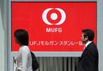Pedestrians walk past the logo for Mitsubishi UFJ Morgan Stanley Securities Co. in Tokyo, Japan.